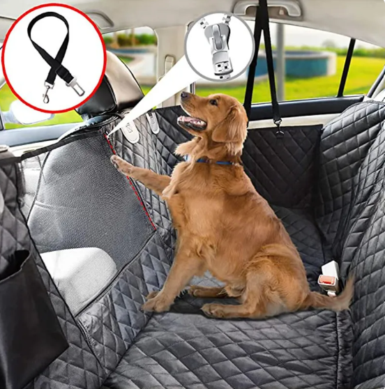 Dog sitting on a car seat cover with a USB light and leash holder in the backseat of a car.